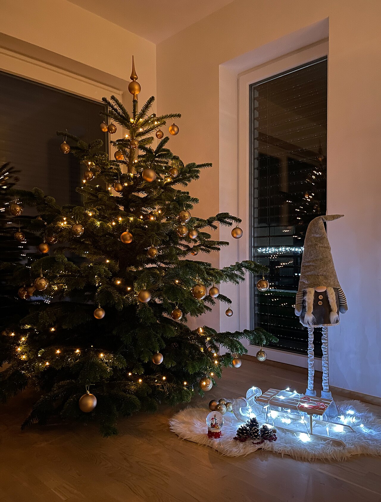 A Christmas tree decorated with baubles and warm golden lights