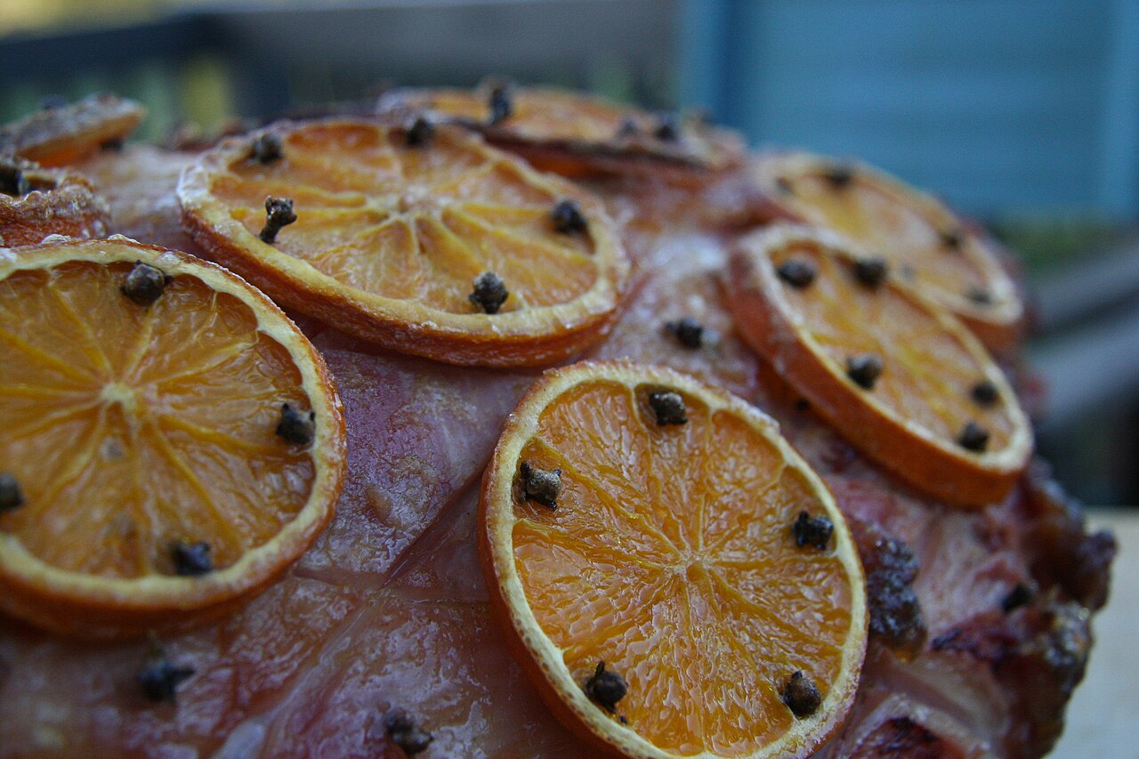 A whole glazed Christmas ham garnished with orange slices