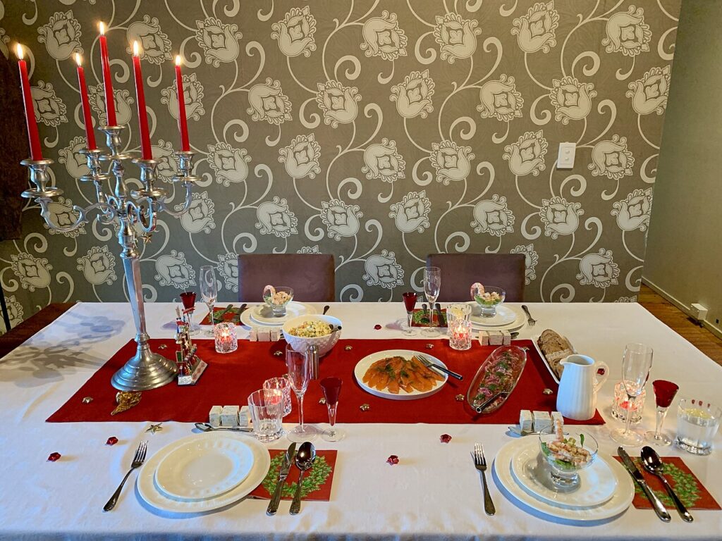 A festive Christmas Eve dinner table set with traditional food