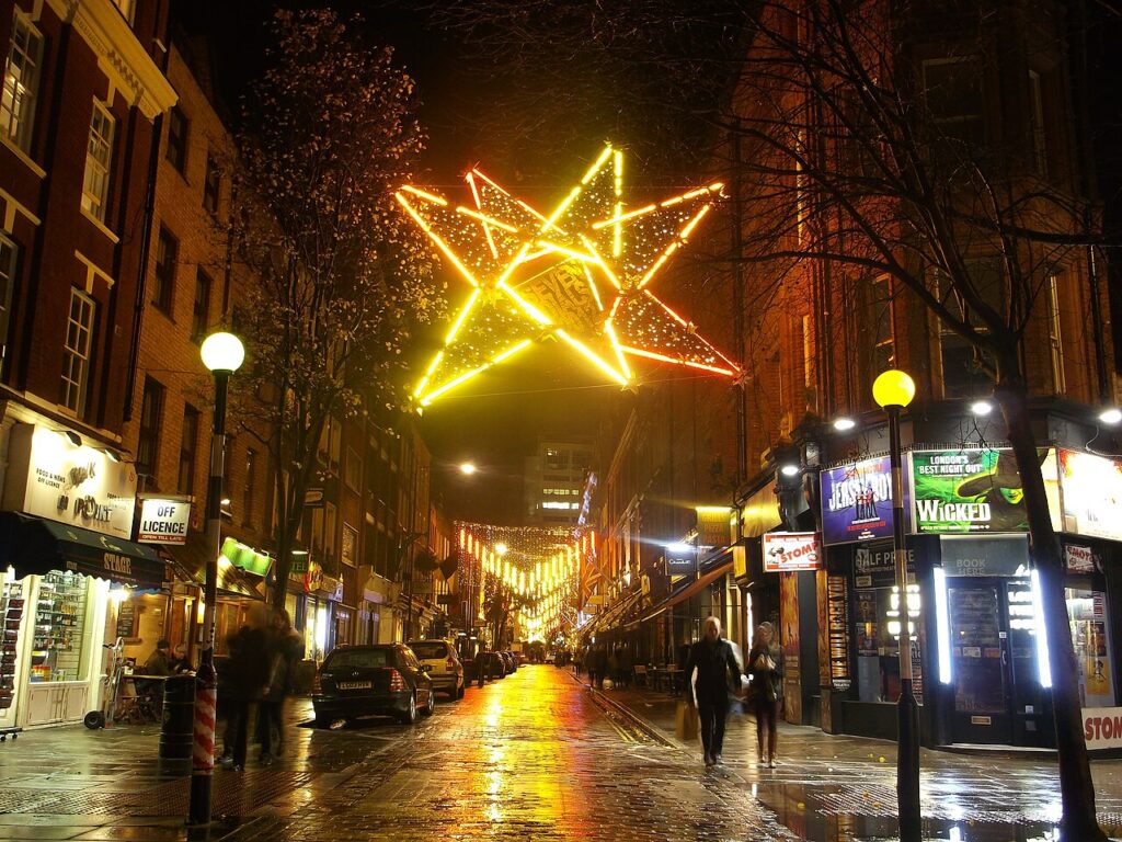 Festive Christmas lights strung across a city street at night